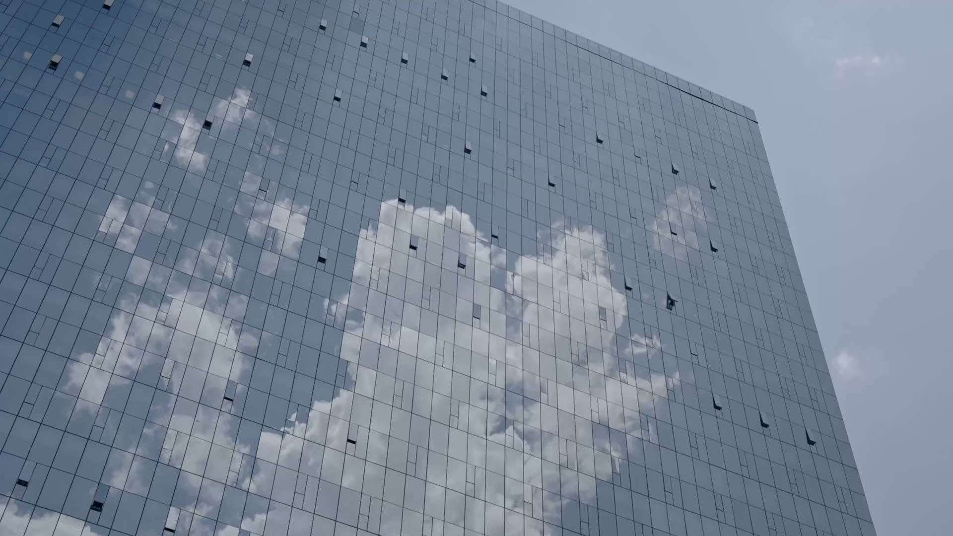 Clouds reflected in the glass facade of a tower