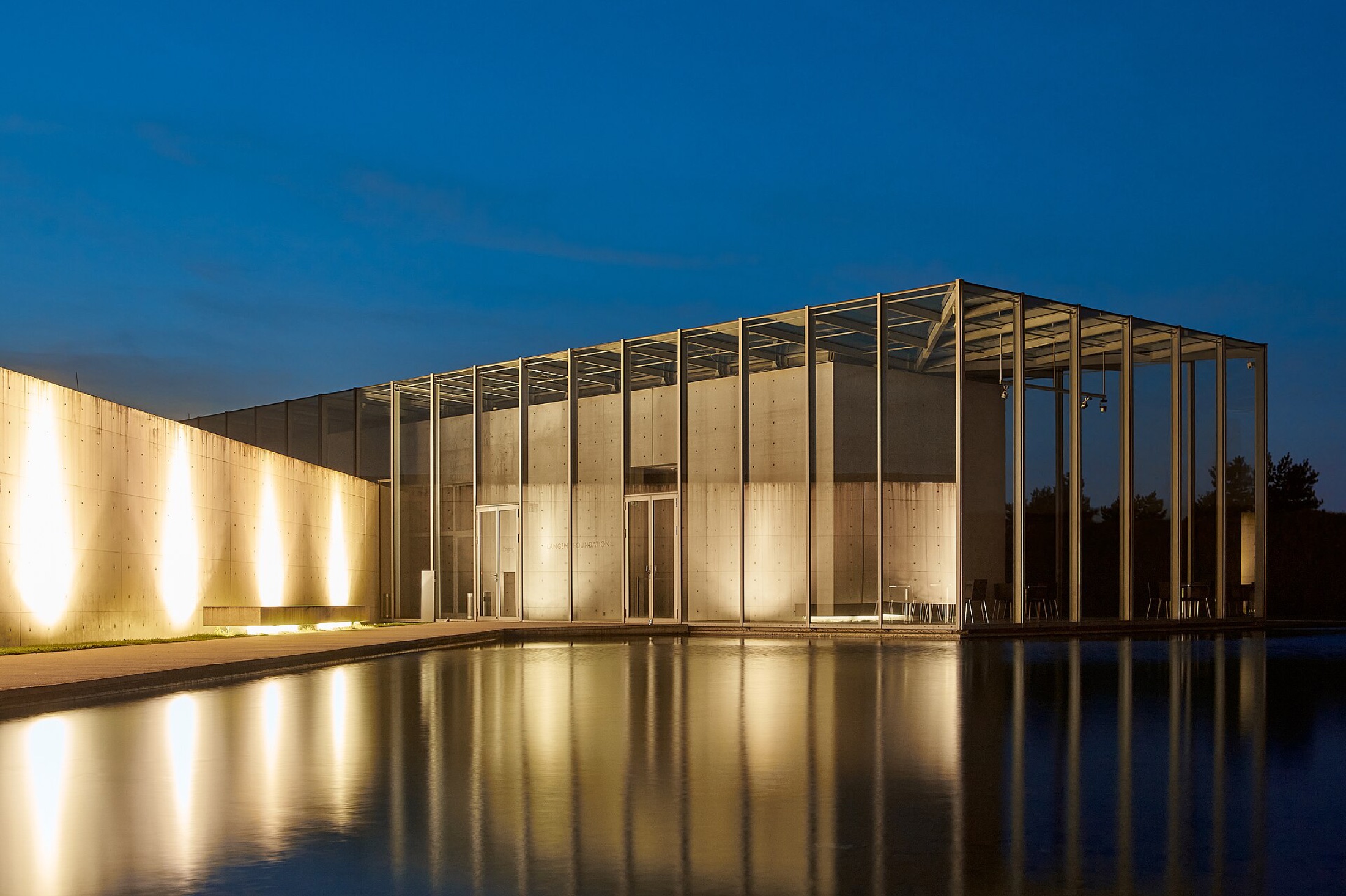 Nightfall Gallery, south elevation at dusk, glass and concrete over a reflecting pool