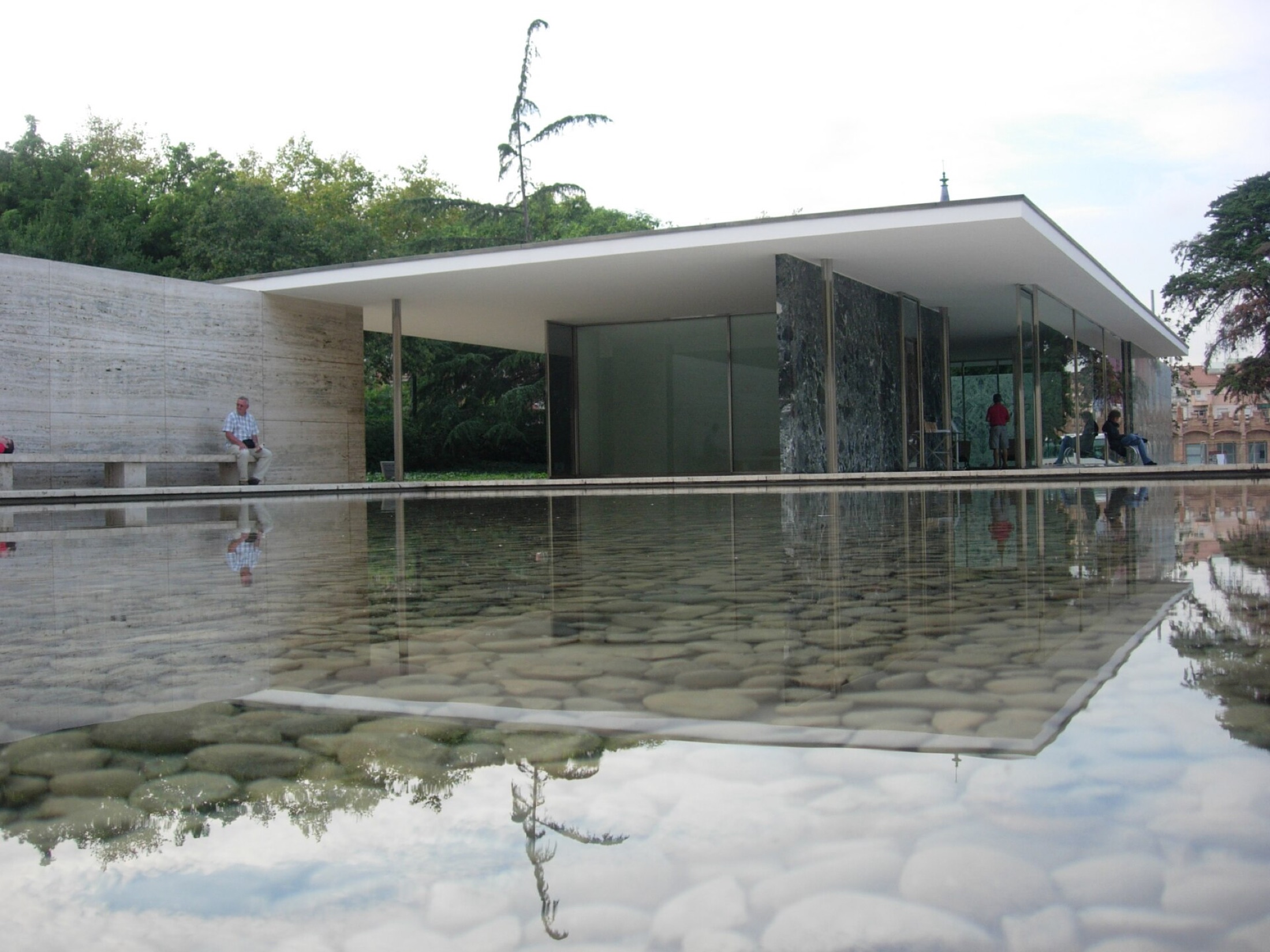 Threshold, a stone and glass garden pavilion over a reflecting pool at dusk